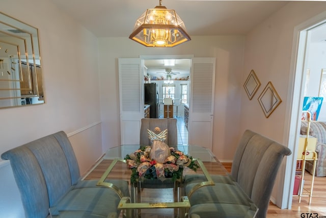 dining space with a notable chandelier and light wood-type flooring