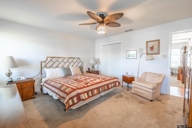 carpeted bedroom featuring ceiling fan and a closet