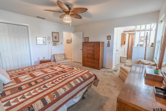 bedroom with ceiling fan, connected bathroom, light carpet, and a closet