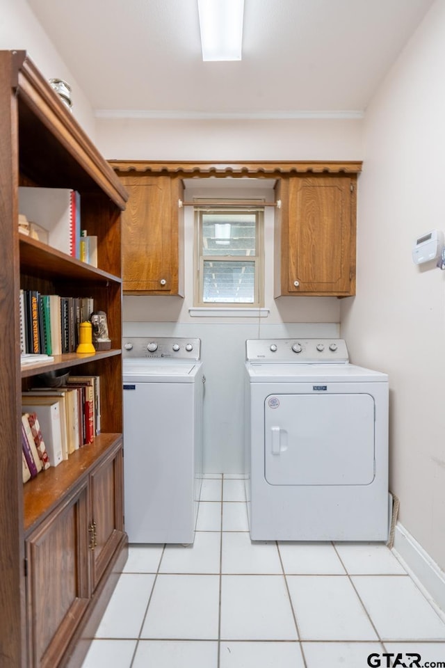 laundry room featuring cabinets, washing machine and clothes dryer, and light tile patterned flooring