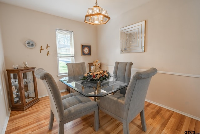 dining room featuring light hardwood / wood-style flooring and a notable chandelier