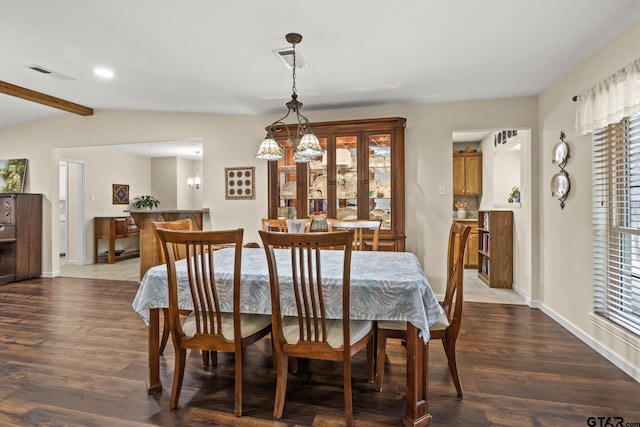 dining space featuring dark hardwood / wood-style flooring and vaulted ceiling with beams