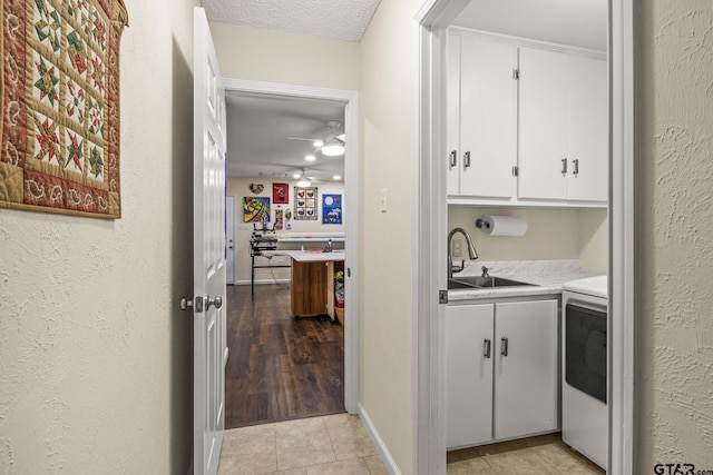 laundry room with sink, light tile patterned floors, ceiling fan, cabinets, and washer / clothes dryer