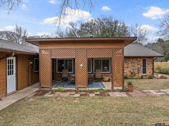 rear view of property featuring a patio and a yard