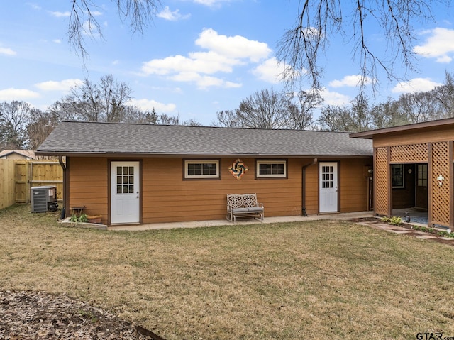 back of property with cooling unit and a yard