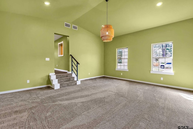 unfurnished living room with vaulted ceiling and carpet flooring