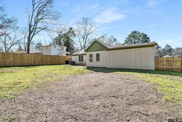 back of house with cooling unit and a lawn