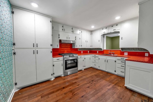 kitchen with sink, dark wood-type flooring, white cabinetry, tasteful backsplash, and stainless steel range with gas cooktop