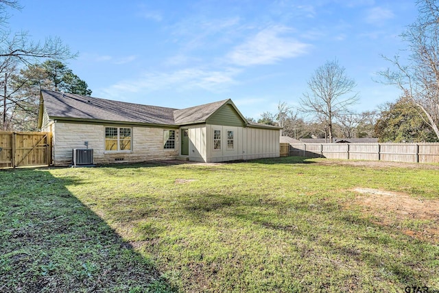 back of property with a lawn and central air condition unit