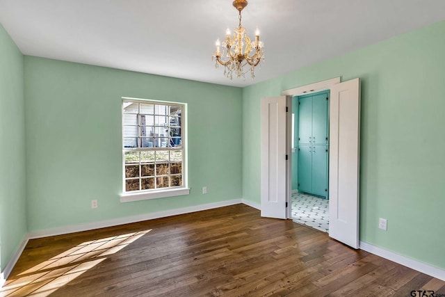 unfurnished room featuring dark hardwood / wood-style floors and a chandelier