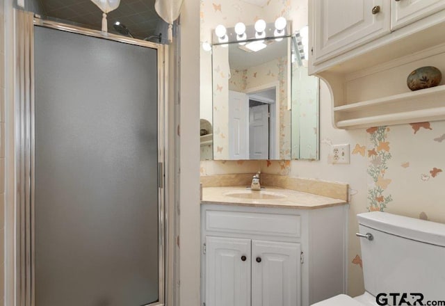 full bathroom featuring toilet, a shower stall, vanity, and wallpapered walls