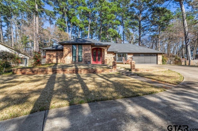 view of front of home with concrete driveway, brick siding, and an attached garage