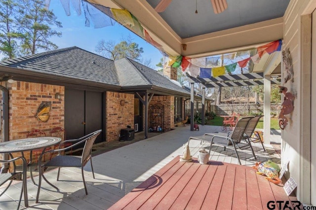 wooden terrace featuring ceiling fan and fence