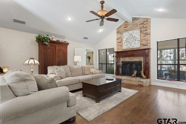 living room with dark wood-type flooring, a brick fireplace, visible vents, and beamed ceiling