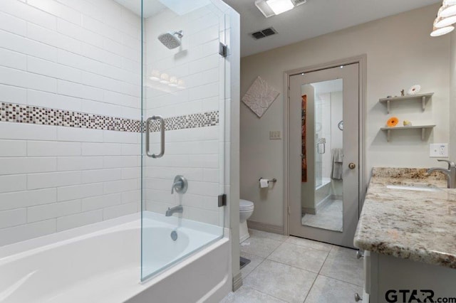 full bath featuring tile patterned flooring, toilet, visible vents, vanity, and combined bath / shower with glass door