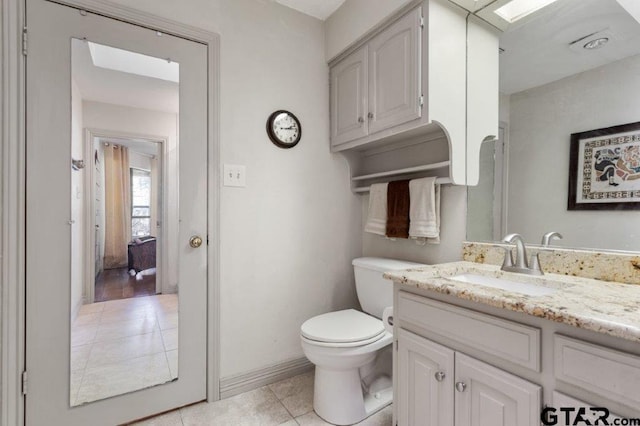 half bath featuring tile patterned flooring, vanity, and toilet