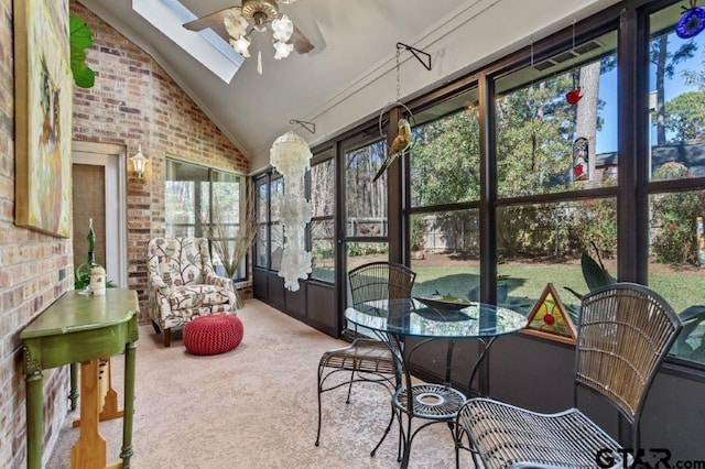 sunroom / solarium featuring lofted ceiling with skylight and ceiling fan