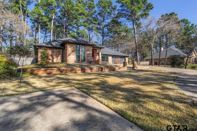 view of front of house with fence, a front lawn, and brick siding