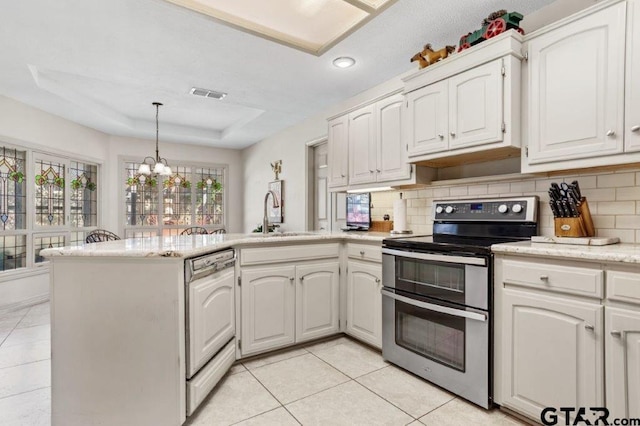 kitchen featuring range with two ovens, a raised ceiling, white cabinets, and dishwasher