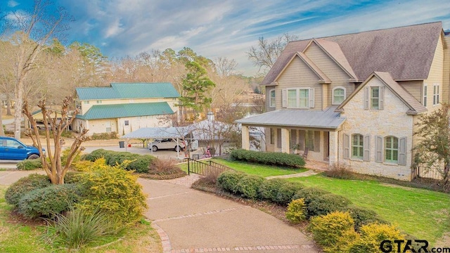 view of front of property featuring stone siding, fence, and a front lawn