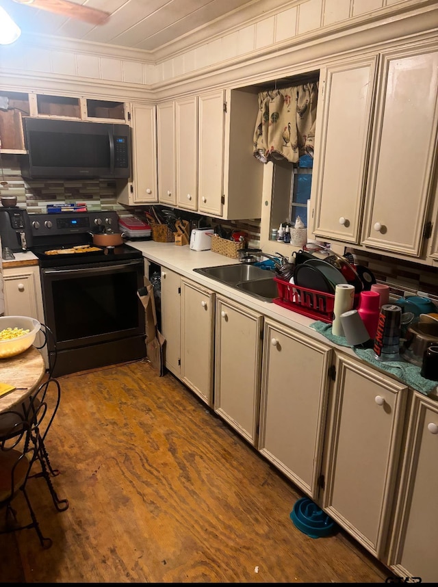 kitchen featuring dark wood-type flooring, range with electric stovetop, ornamental molding, and sink