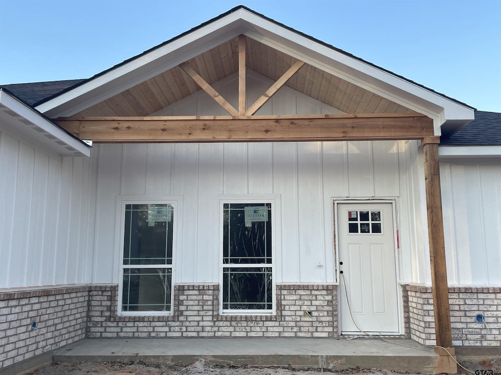 view of exterior entry with a patio