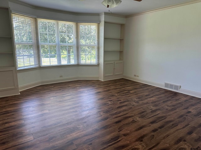 spare room featuring ceiling fan, plenty of natural light, dark hardwood / wood-style flooring, and crown molding