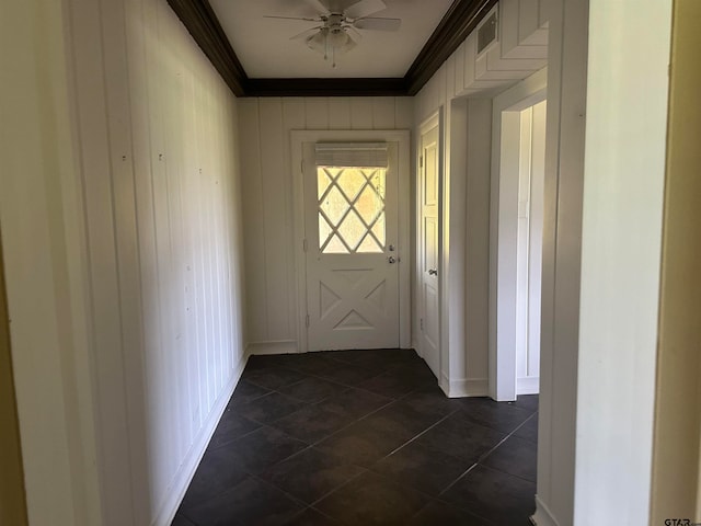 doorway featuring dark tile patterned floors, crown molding, and ceiling fan