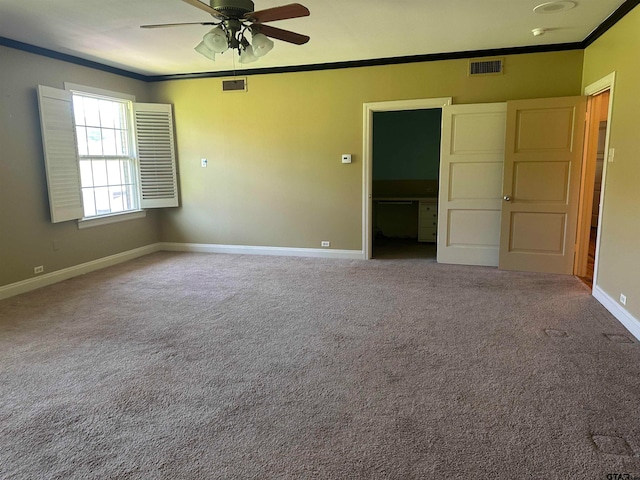 carpeted spare room with ceiling fan and ornamental molding