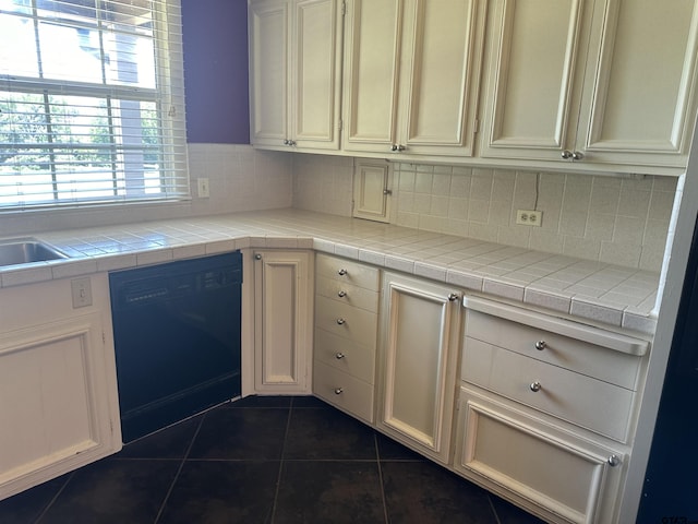 1248 Canada St, Jacksonville, TX 75766 - kitchen with dishwasher, dark tile patterned floors, decorative backsplash, and white cabinets
