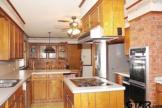 kitchen featuring hanging light fixtures, a textured ceiling, brick wall, and black appliances