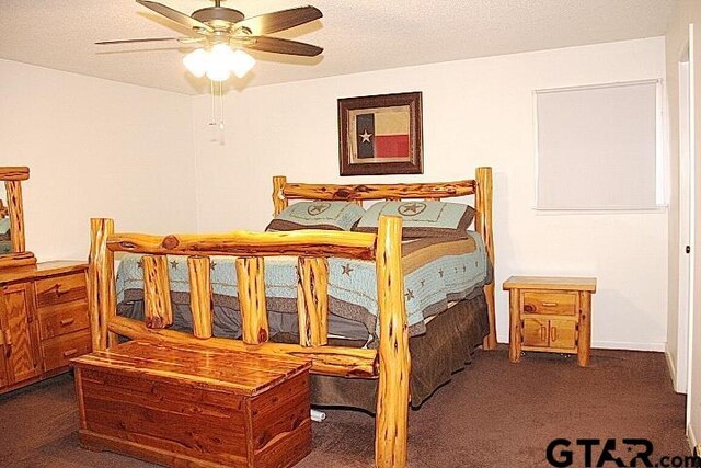 bedroom featuring ceiling fan, a textured ceiling, and dark carpet