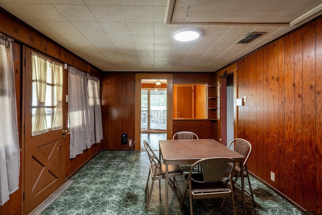 dining space with wood walls