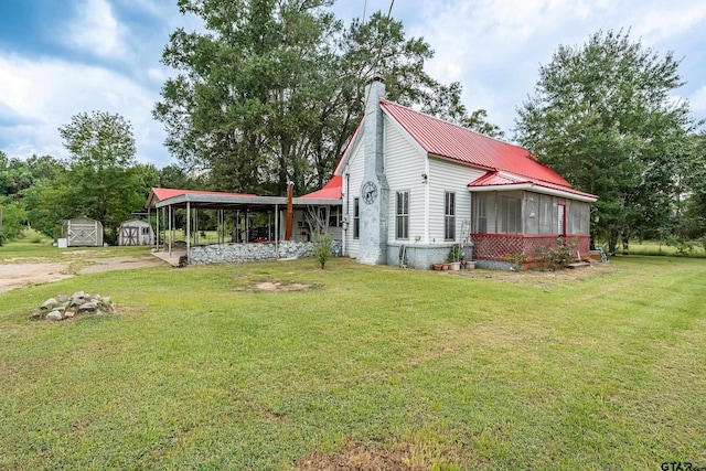 view of property exterior with a storage shed, a lawn, and a sunroom