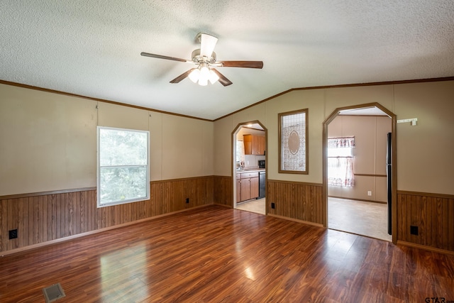 empty room featuring wood-type flooring, a textured ceiling, and lofted ceiling