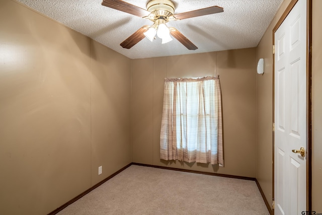 carpeted spare room featuring ceiling fan and a textured ceiling