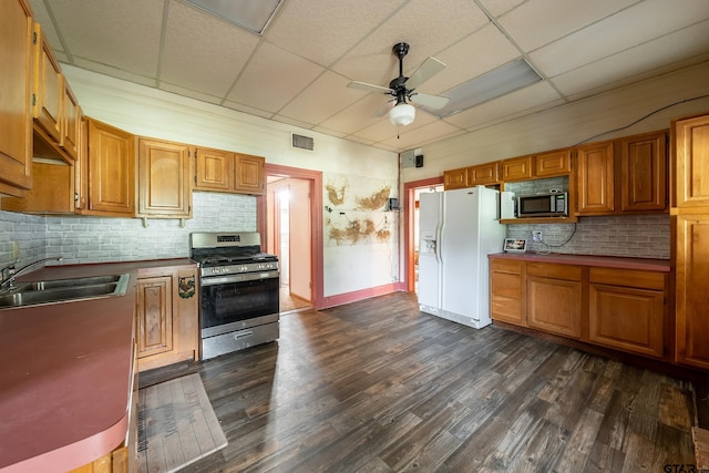 kitchen with stainless steel appliances, backsplash, dark hardwood / wood-style flooring, sink, and a drop ceiling