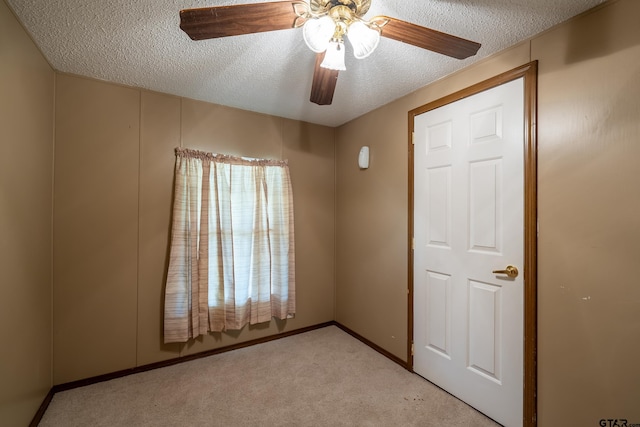 unfurnished bedroom featuring a textured ceiling, light carpet, and ceiling fan