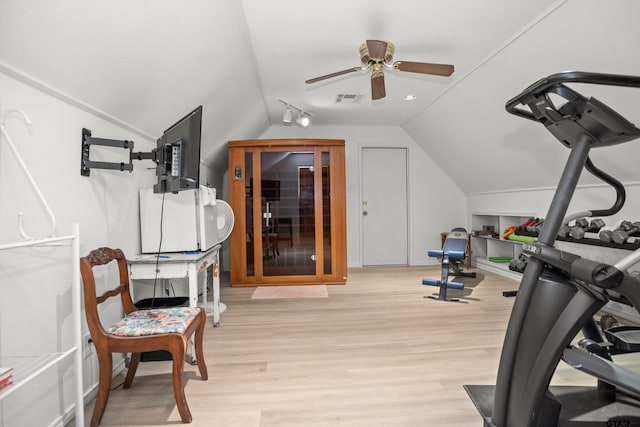 exercise area featuring light hardwood / wood-style flooring, vaulted ceiling, and ceiling fan