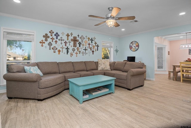 living room with plenty of natural light, ceiling fan, ornamental molding, and light hardwood / wood-style flooring