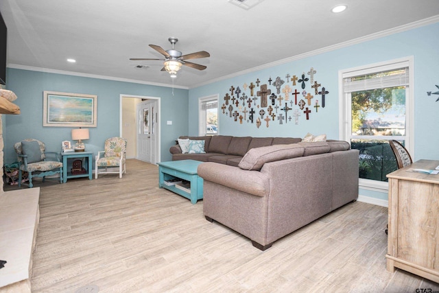 living room with light wood-type flooring, a wealth of natural light, and ornamental molding