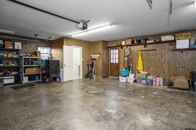 garage featuring wood walls and a garage door opener