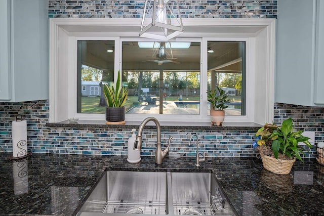 kitchen with backsplash, dark stone countertops, and a healthy amount of sunlight