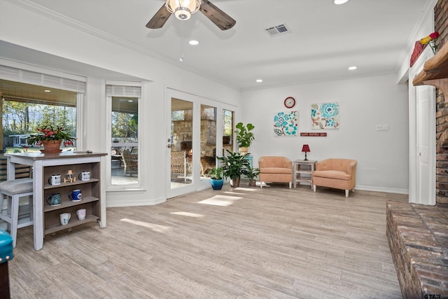 living area featuring ceiling fan, light hardwood / wood-style floors, and ornamental molding