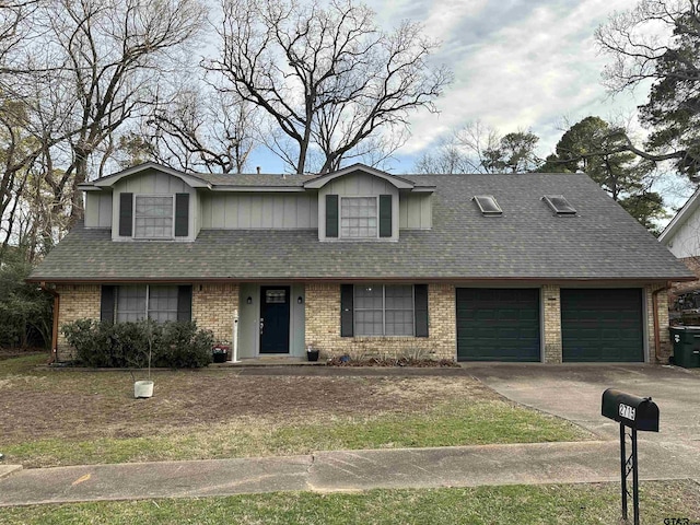 traditional-style home featuring a garage, a shingled roof, concrete driveway, and brick siding