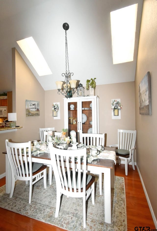 2333 Baretta Dr, Mesquite, TX 75181 - dining room with a skylight, vaulted ceiling, wood finished floors, a chandelier, and baseboards