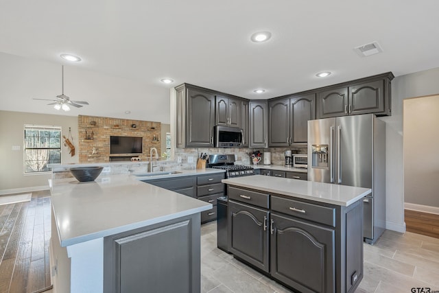 8533 Fm 315, Frankston, TX 75763 - kitchen featuring appliances with stainless steel finishes, a peninsula, a center island, light countertops, and ceiling fan
