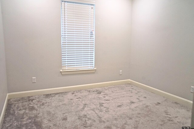 carpeted empty room with baseboards