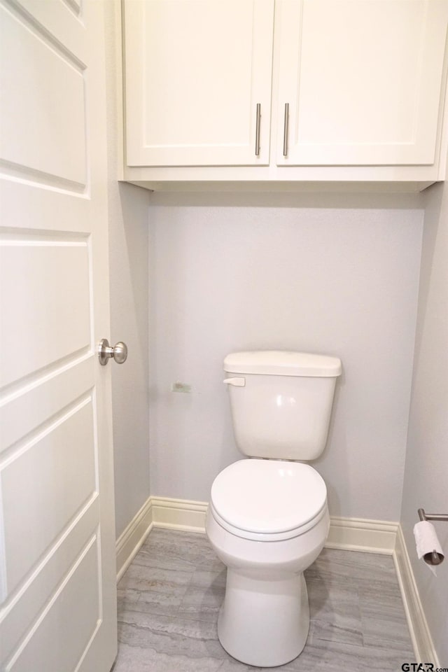 bathroom with baseboards and toilet