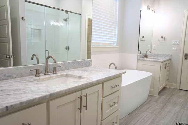bathroom with a sink, two vanities, and a shower stall